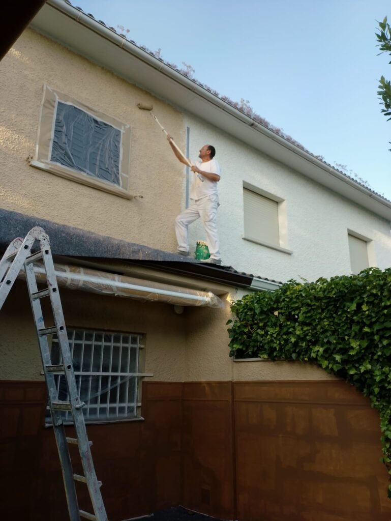 pintando fachada de tirolesa en Moralzarzal