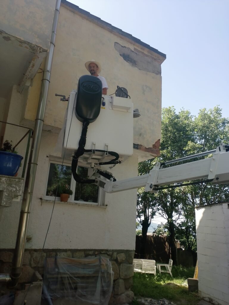 rehabilitación y pintado de fachada usando camión cesta